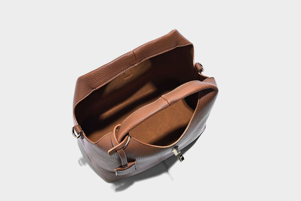 Structured pebbled-texture bucket bag with arched top handles, gold-tone turn-lock closure, and detachable shoulder strap