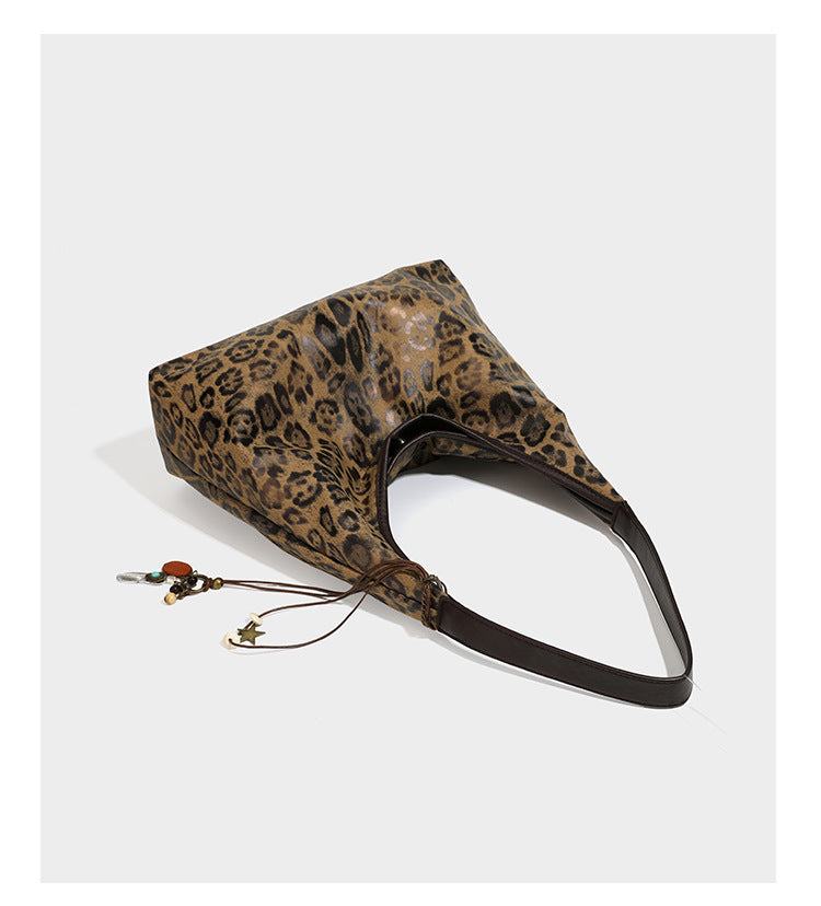 Weich fallende Hobo-Tote-Bag mit Leopardenmuster in Beige und Braun, dunkelbraunem Riemen in Lederoptik und herabhängenden Perlenanhänger-Beschlägen
