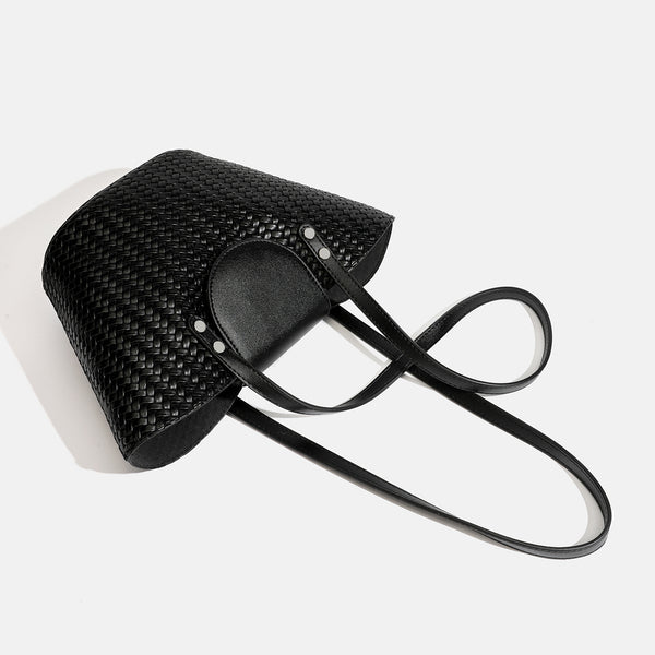 Schwarze geflochtene Trapez-Schultertasche mit glatter Frontklappe, silberfarbenen Nieten, zwei langen Riemen und passendem Innenetui mit Reißverschluss
