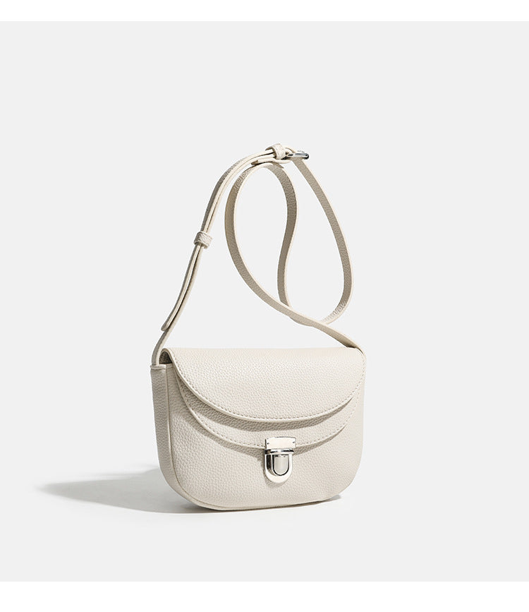 Mini-Crossbody-Satteltasche mit genarbter Oberfläche, silberfarbenem Drehverschluss an der Klappe und verstellbarem Schulterriemen, Detailansicht 9
