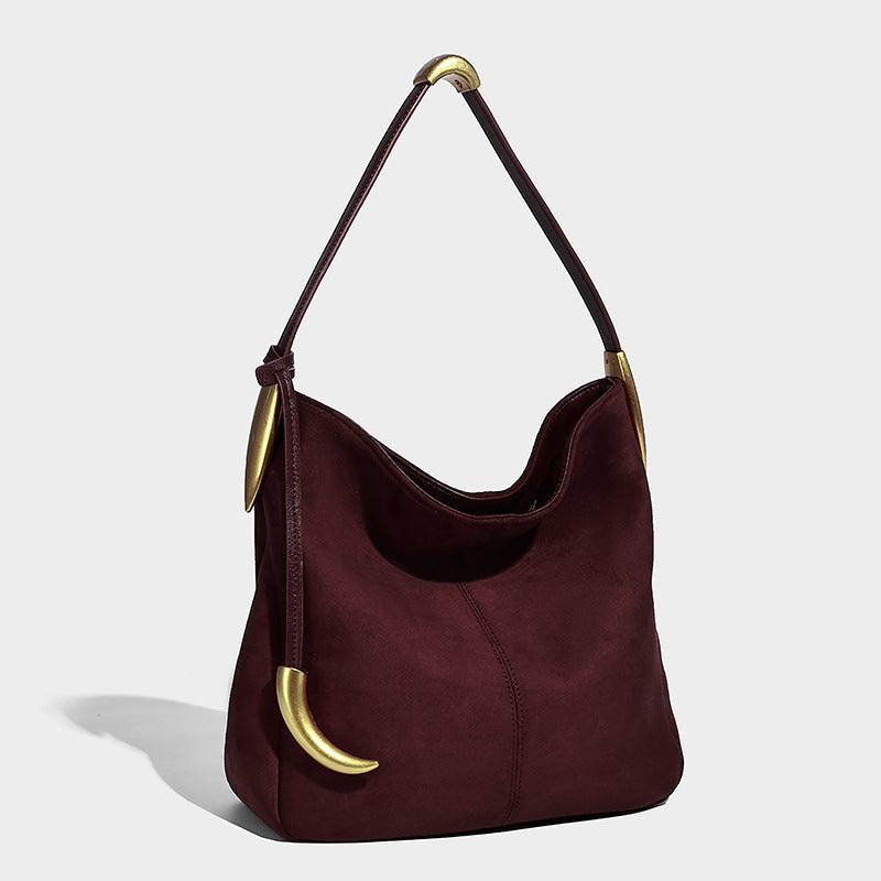 Weich fallende Hobo-Schultertasche in brauner matter Veloursleder-Optik mit goldfarbenen Halbmond-Beschlägen und schmalem Schulterriemen, Detailansicht