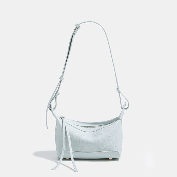 Small structured mini crossbody shoulder bag with pebbled texture, knotted adjustable strap, top zip closure, and gold-tone