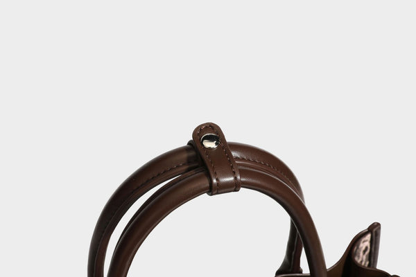 Structured leopard-print tote bag with glossy satin-like finish, dual rounded top handles, silver buckle-and-ring front