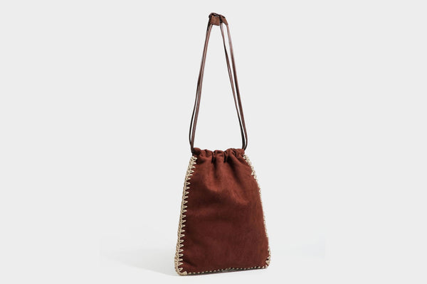 Matte suede-look drawstring bucket bag with cream braided woven edge trim and slim adjustable leather-look shoulder strap