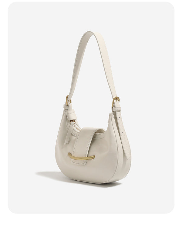 Compact crescent hobo shoulder bag with glossy synthetic finish, curved gold-tone front bar hardware, zip-top closure, and