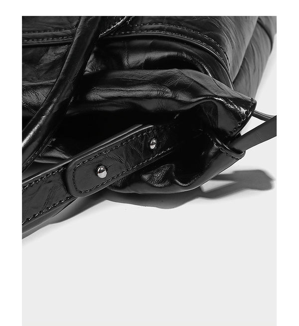 Glossy crinkled ruched drawstring bucket bag with rounded double top handles and detachable chain crossbody strap, detail