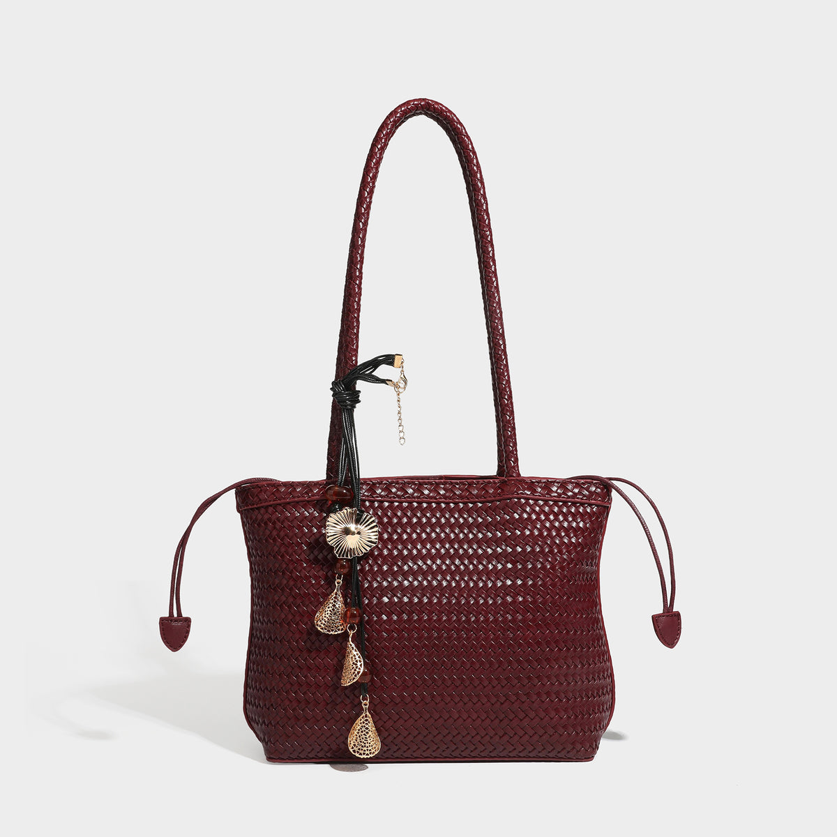 Structured woven leather-look tote bag in dark brown with long shoulder straps, side drawstring ties, and gold filigree