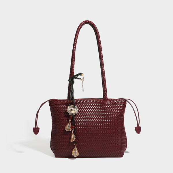 Structured woven leather-look tote bag in dark brown with long shoulder straps, side drawstring ties, and gold filigree