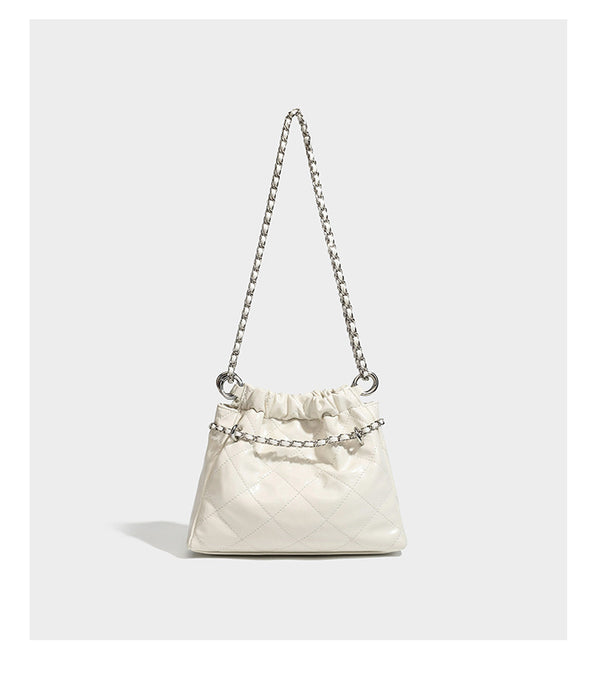 Glossy diamond-quilted drawstring bucket bag with silver chain shoulder strap and medallion charm, detail view 17