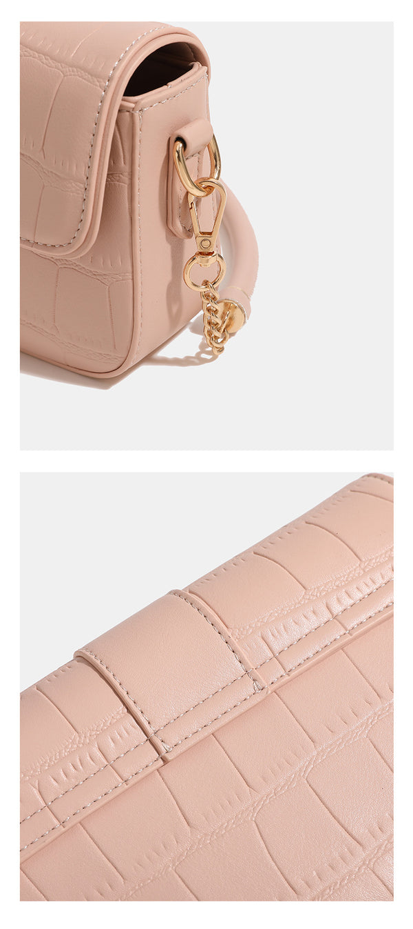 Small structured crocodile-embossed flap shoulder bag with circular gold turn-lock closure and chain-accent strap, detail