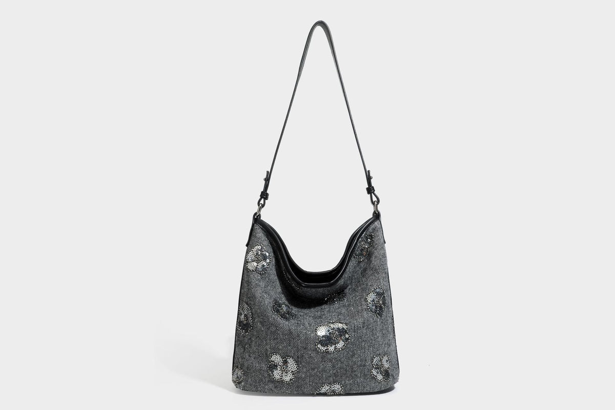 Lässig fallende Hobo-Schultertasche aus anthrazitfarbenem Webstoff mit floraler Stickerei aus silberfarbenen Pailletten, schwarzem Besatz in Lederoptik und langem