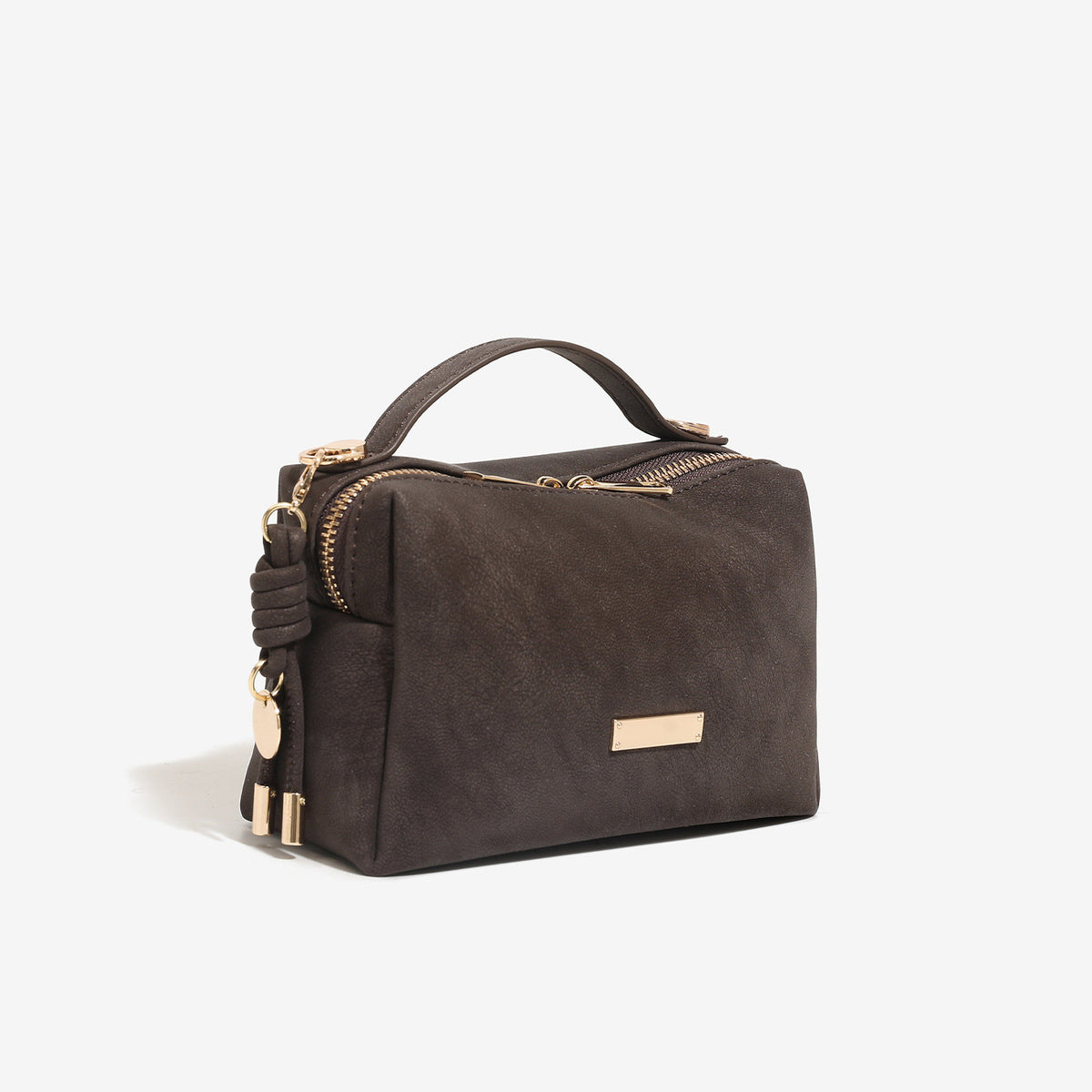 Compact boxy mini handbag with matte pebbled finish, dual top zipper, short top handle, side tassel charm, and gold-tone