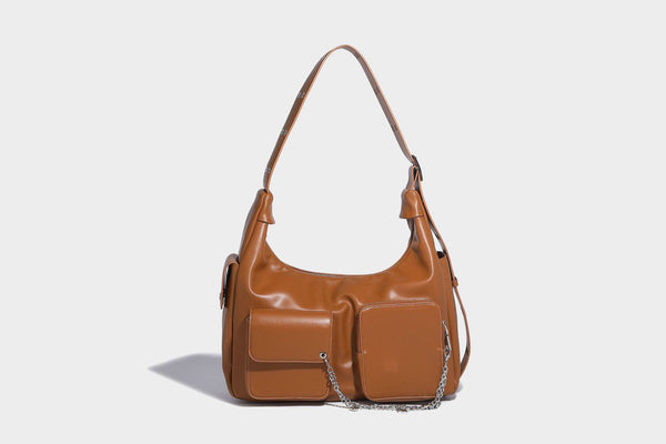 Lässig fallende Hobo-Schultertasche mit glänzender Lederoptik, vorderen Klappentaschen, Kettenapplikationen und silberfarbenen Nietbeschlägen