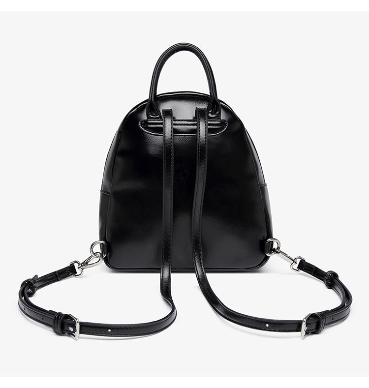 Kleine kuppelförmige Mini-Rucksackhandtasche in Pastellgelb mit glatter Lederoptik, oberem Bogenreißverschluss und silberfarbenen Details, Detailansicht