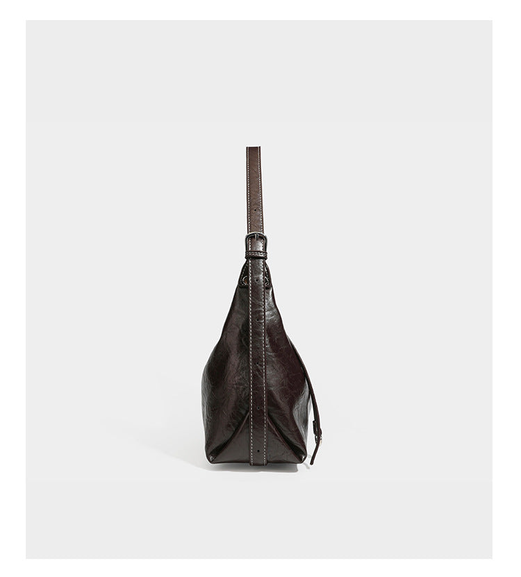 Slouchy hobo shoulder bag in glossy crinkled leather-look finish with zip-top closure and silver-tone ring hardware, detail