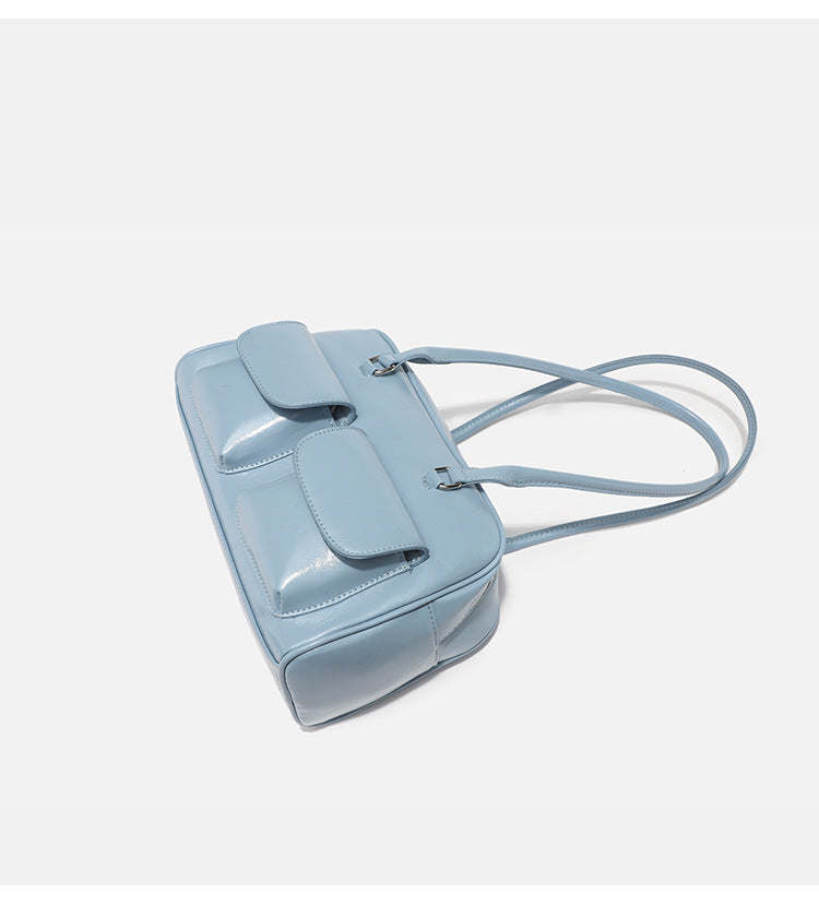 Structured glossy leather-look bowling shoulder bag with two front flap pockets, top zip closure, and long double shoulder