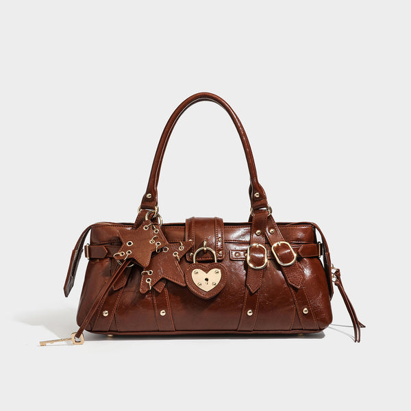 Dark brown glossy crinkled leather-look barrel bag with gold heart lock, dome studs, star charm, dual top handles and, detail
