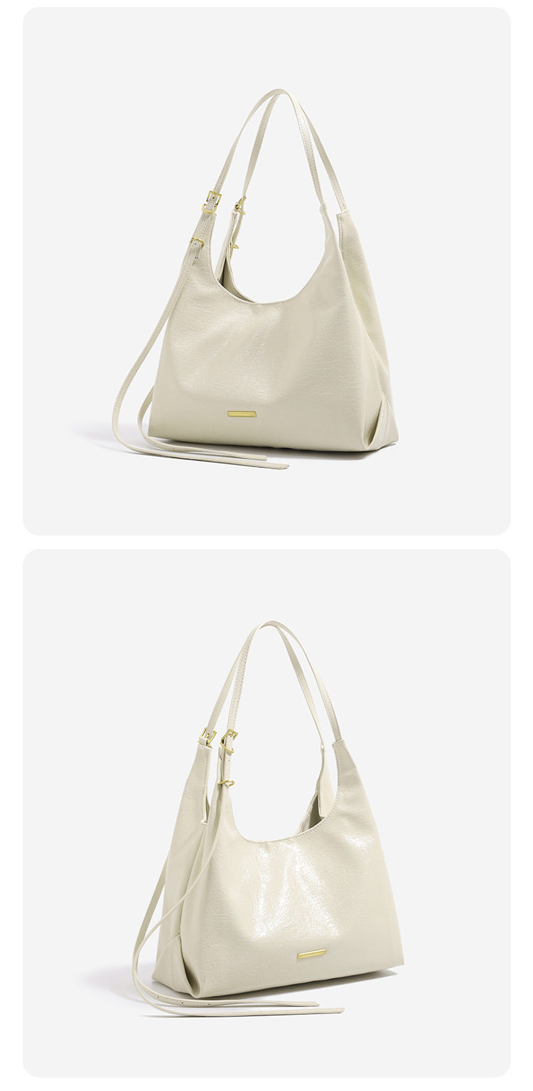 Slouchy hobo shoulder bag in crinkle high-gloss leather-look finish with gold-tone bar hardware and adjustable strap, detail