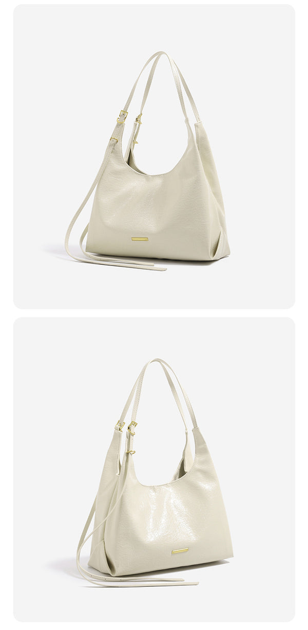 Slouchy hobo shoulder bag in crinkle high-gloss leather-look finish with gold-tone bar hardware and adjustable strap, detail