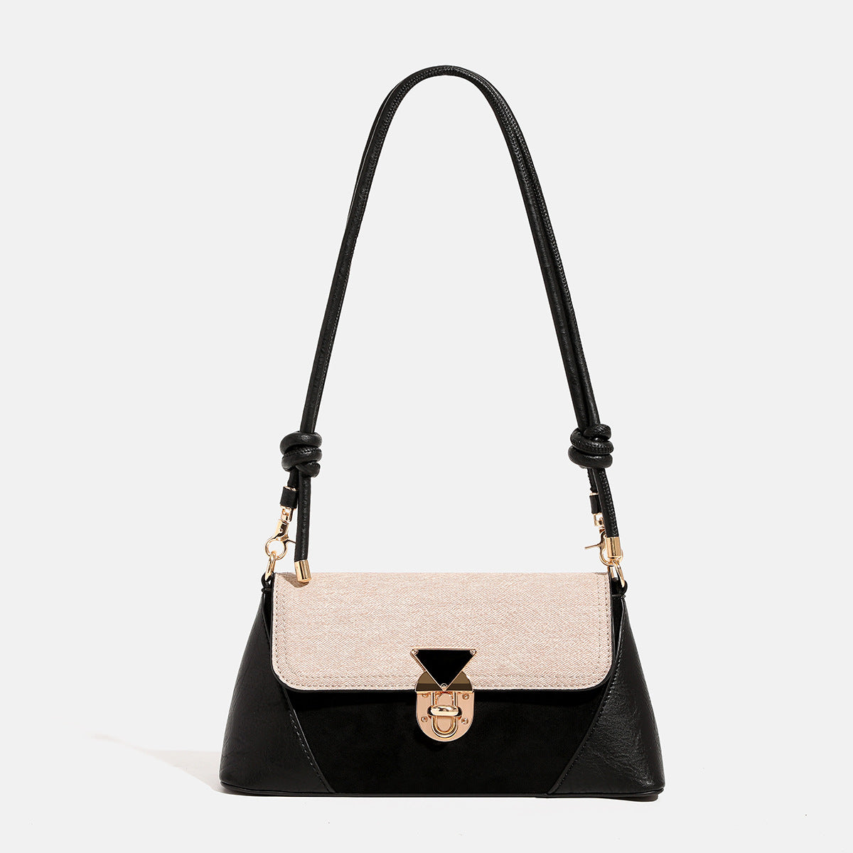 Structured trapezoid shoulder bag with pale textured flap, gold-tone triangular turn-lock closure, and long knotted cord