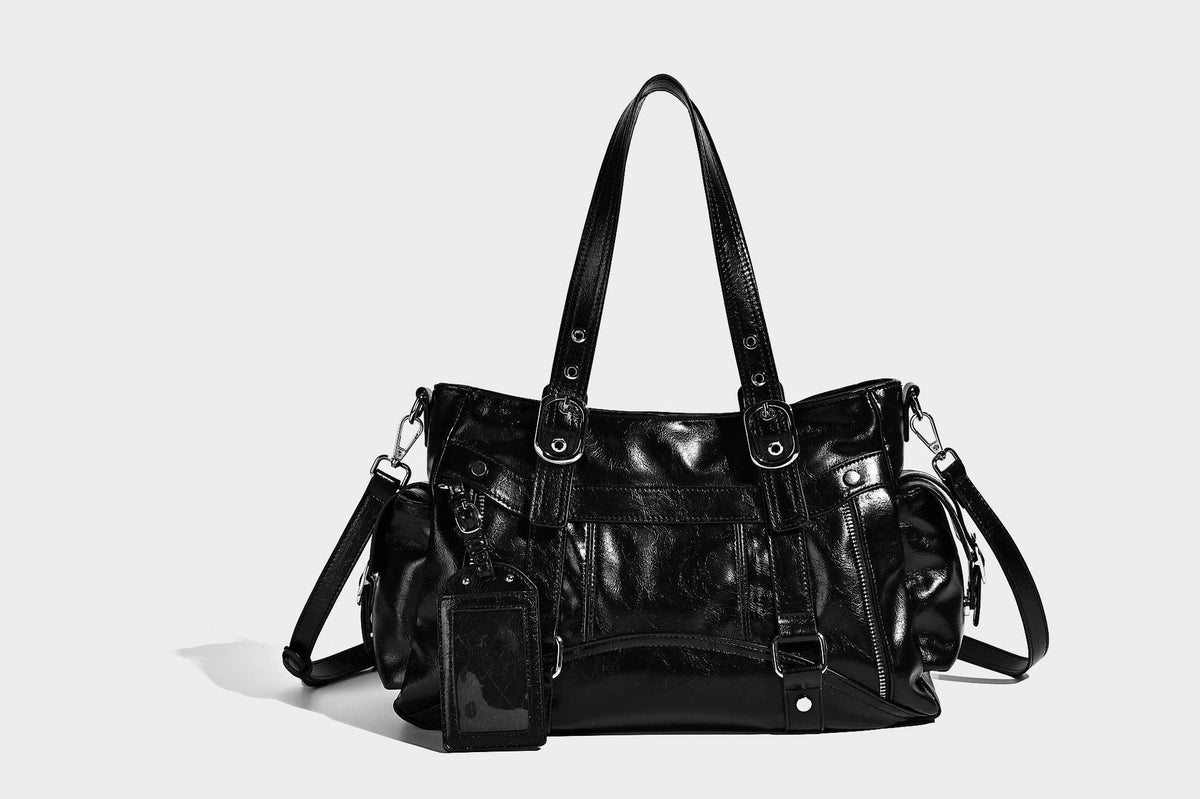 Glossy structured black tote shoulder bag with silver buckle hardware, zip pockets, dual top handles, and detachable, detail