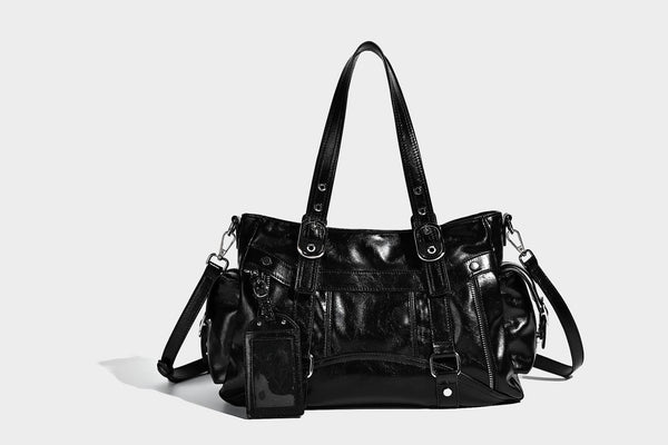 Glossy structured black tote shoulder bag with silver buckle hardware, zip pockets, dual top handles, and detachable, detail