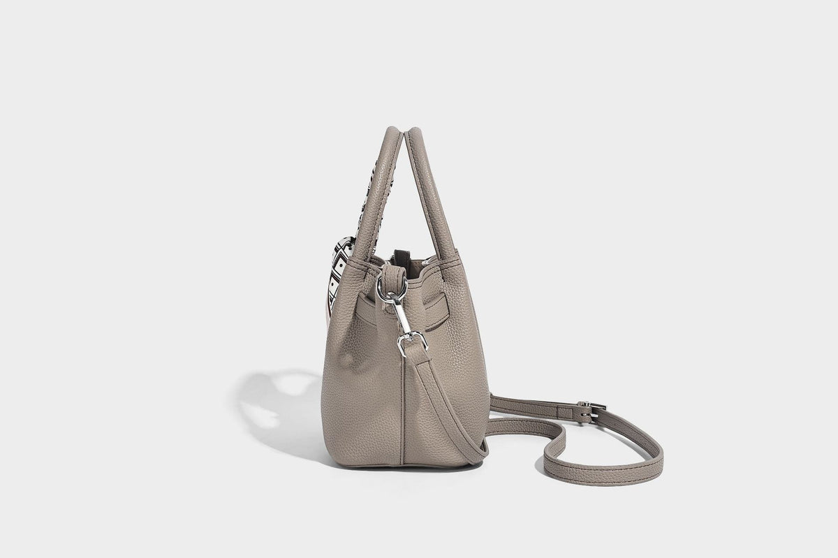 Kleine strukturierte Henkeltasche mit genarbter Oberfläche in Taupe, zwei Tragegriffen, bedrucktem Schalband, Drehverschluss an der Vorderseite und, Detail