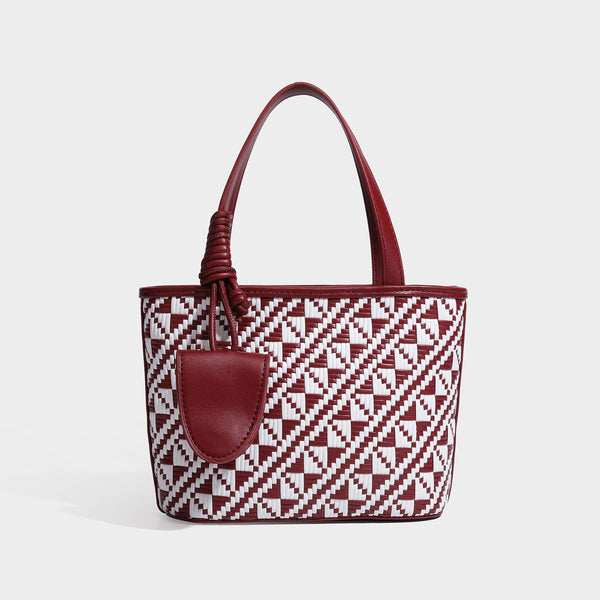 Kleiner, strukturierter Shopper mit gewebtem geometrischem Muster, glatten Besätzen in Lederoptik, geknoteten Henkeln, Reißverschluss und herabhängendem Frontdetail
