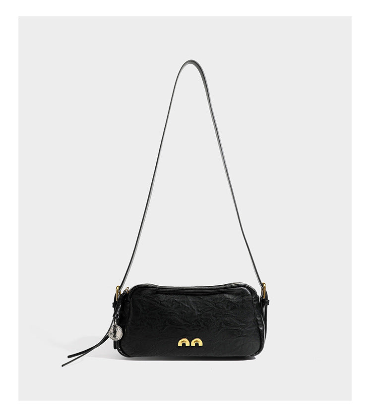 Compact black crinkled leather-look baguette shoulder bag with gold-tone arch hardware and adjustable strap, detail view 12