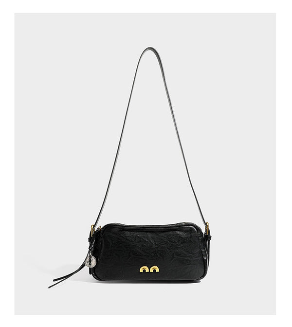 Compact black crinkled leather-look baguette shoulder bag with gold-tone arch hardware and adjustable strap, detail view 12