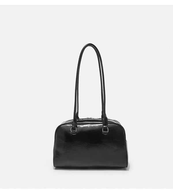 Structured glossy leather-look bowling shoulder bag with two front flap pockets, top zip closure, and long double shoulder