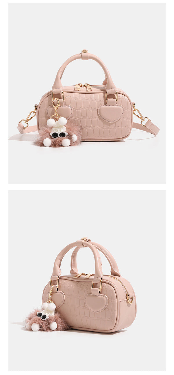 Mini croc-embossed barrel handbag with gold-tone hardware, dual zip top handles, detachable crossbody strap, and fluffy