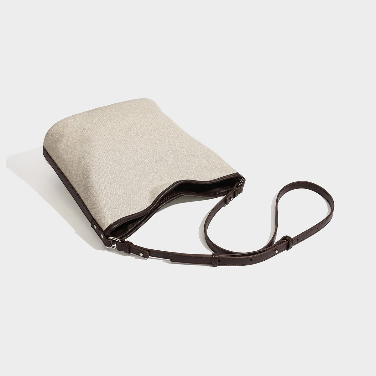 Cremefarbene Canvas-Beuteltasche mit dunkelbraunem Besatz in Lederoptik, geknotetem Riemen und befestigter Mini-Tasche, Detailansicht 4