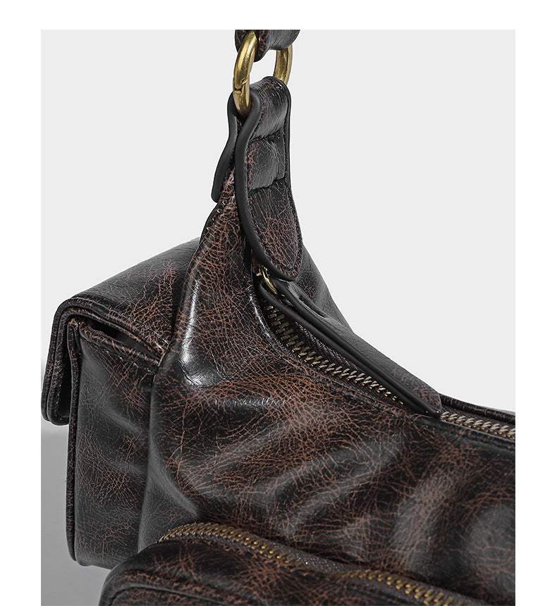 Formlose Schultertasche in Lederoptik mit mehreren Fächern, Used-Finish, vorderer Reißverschlusstasche, seitlichen Klappentaschen und goldfarbenem