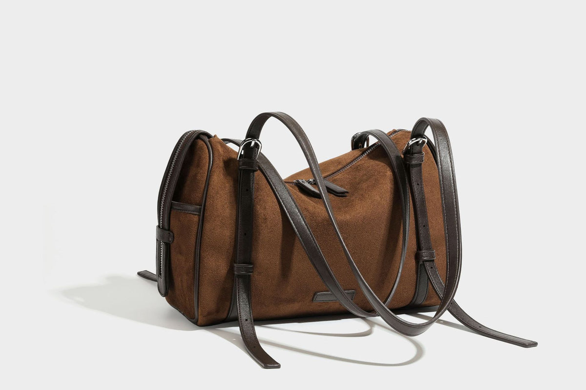 Large brown suede-finish barrel shoulder bag with dark leather-look trim, silver-tone zippers, dual top handles, and long