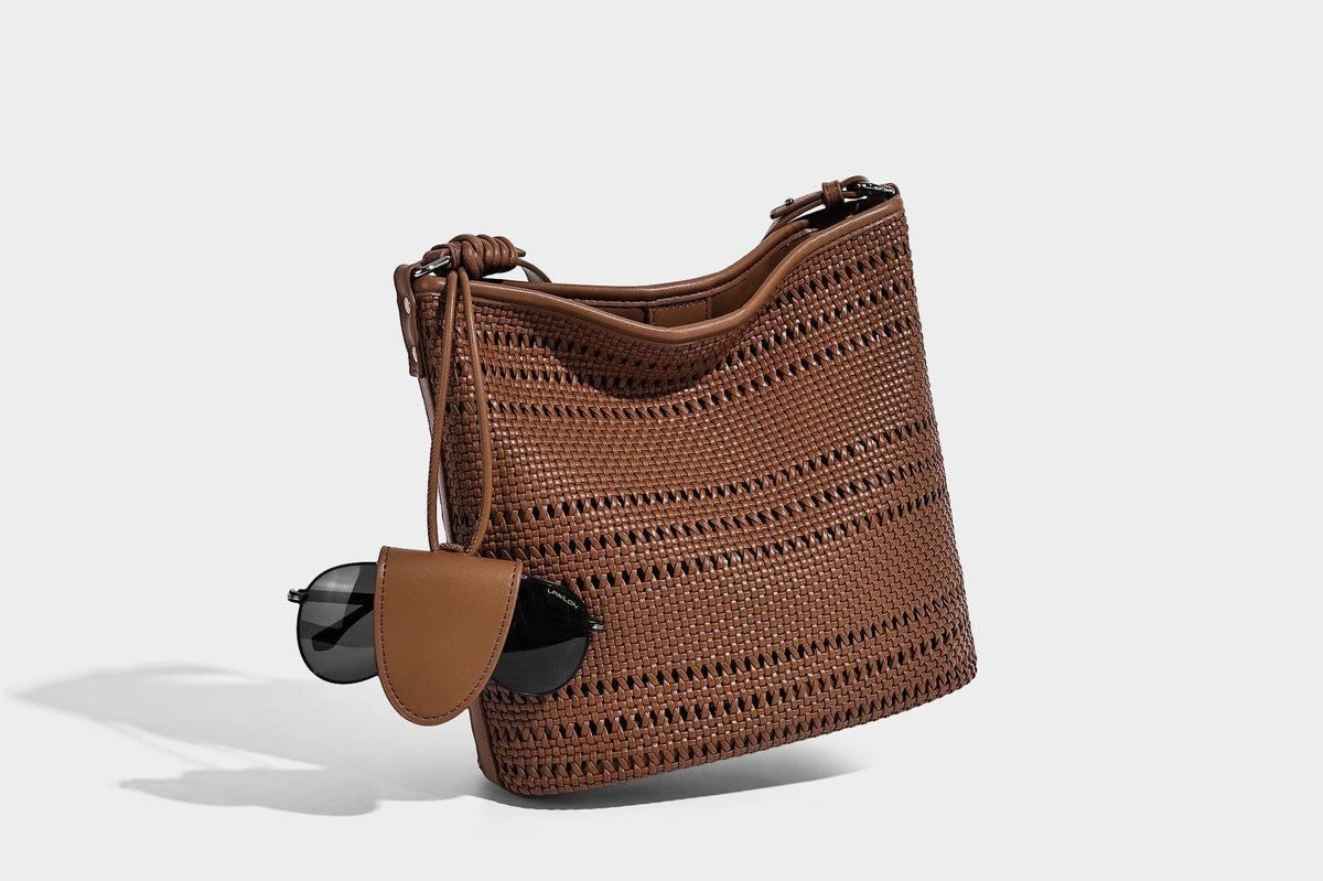 Handwoven open-weave shoulder bag with leather-look trim, knotted adjustable strap, and clip-on sunglasses sleeve pouch