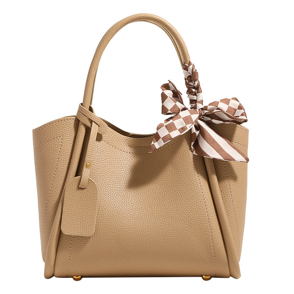 Structured pebbled tote bucket bag in apricot with braided top handle, checkered bow scarf, gold-tone hardware, and, detail