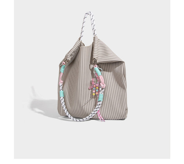 Slouchy pinstripe tote bag with braided rope handles, metal ring hardware, and colorful knotted rope charm, detail view 13