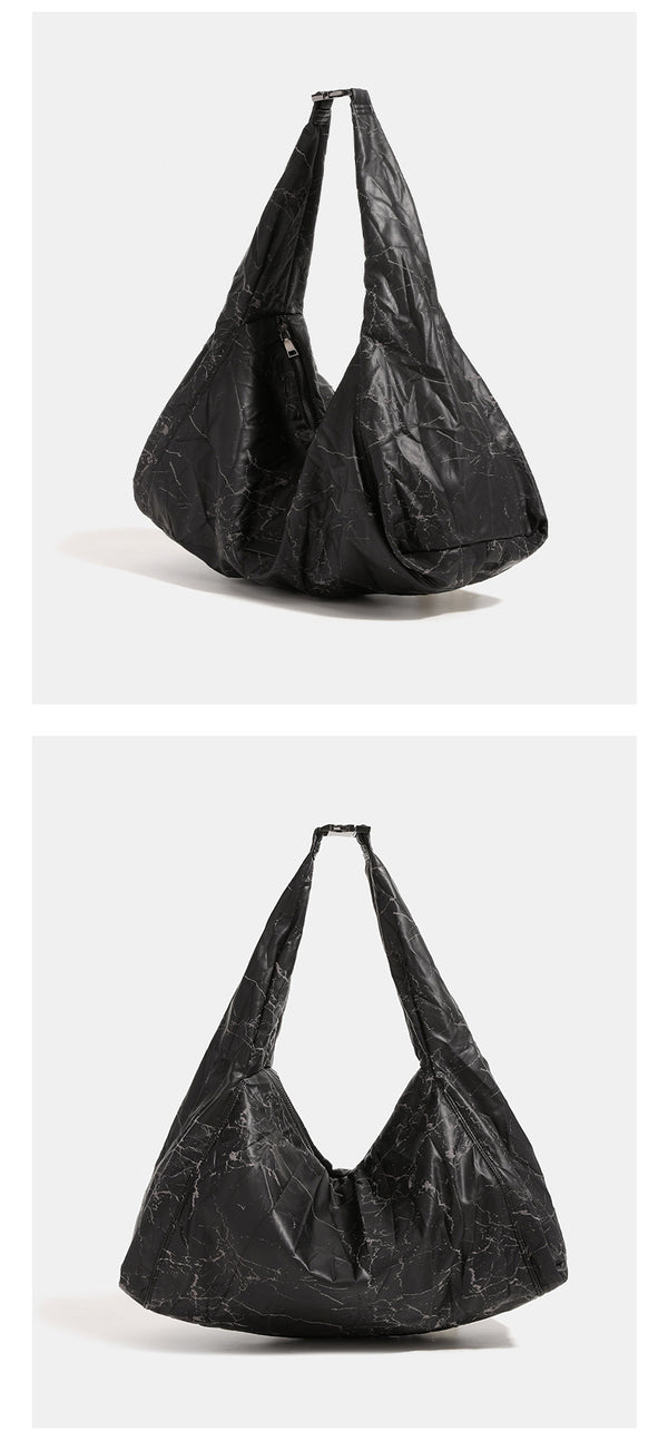 Oversized slouchy hobo shoulder bag in dark marled denim-texture fabric with top zip closure and adjustable single strap