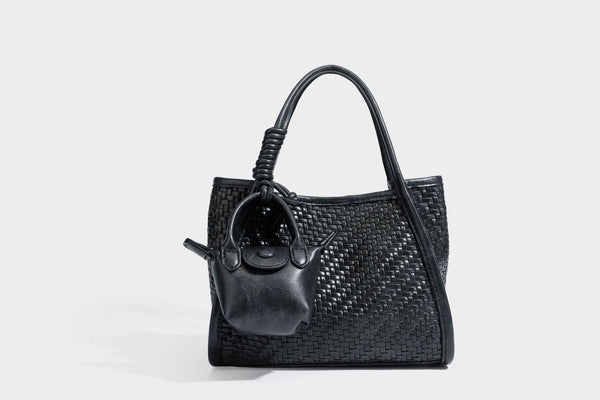 Strukturierte Tote-Bag mit Webstruktur in Braun, glattem Besatz in Lederoptik, geknoteten Henkeln und angehängtem Mini-Beutel mit Kordelzug