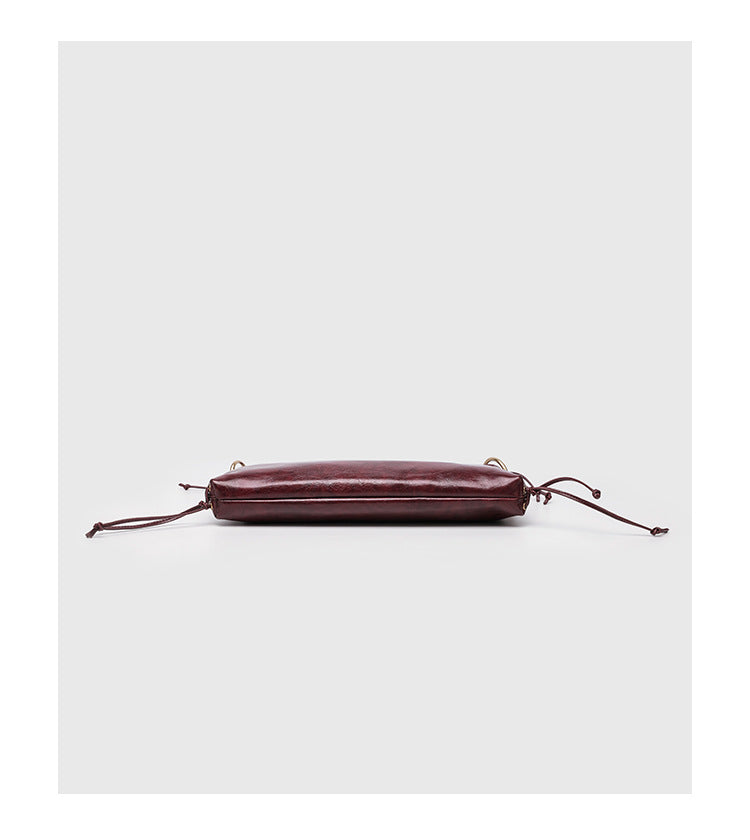Large slouchy hobo shoulder bag with braided top handle, gold-tone O-ring hardware, and lace-up side cord detailing in