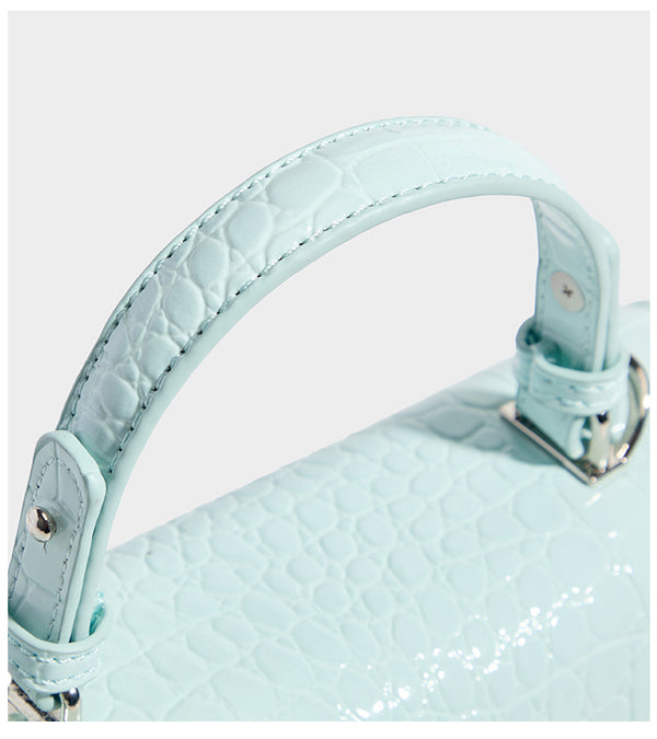 Small structured rectangular satchel with glossy crocodile-embossed finish, arched top handle, front flap, and silver-tone