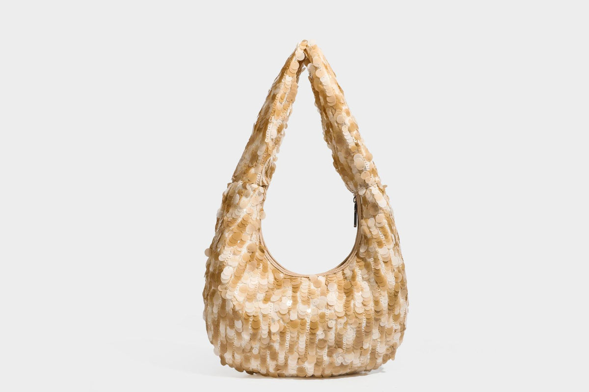 Slouchy crescent hobo shoulder bag covered in overlapping reflective sequin discs with a single integrated strap and top-zip