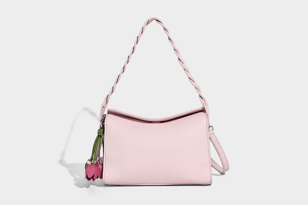 Small structured pebbled-finish shoulder bag with braided top handle, detachable crossbody strap, floral tassel charm, and