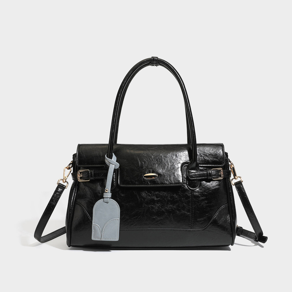 Structured glossy leather-look satchel bag with flap closure, gold-tone buckle accents, double top handles, detachable