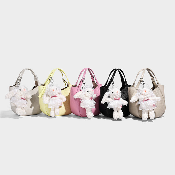 Small pebbled half-moon shoulder bag with dual top handles, detachable crossbody strap, and silver-tone hardware, detail view