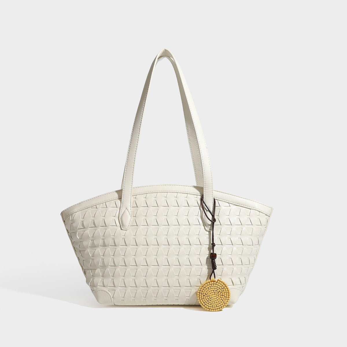Large leather-look tote bag with geometric woven emboss, double shoulder straps, and round woven cord charm in brown, detail