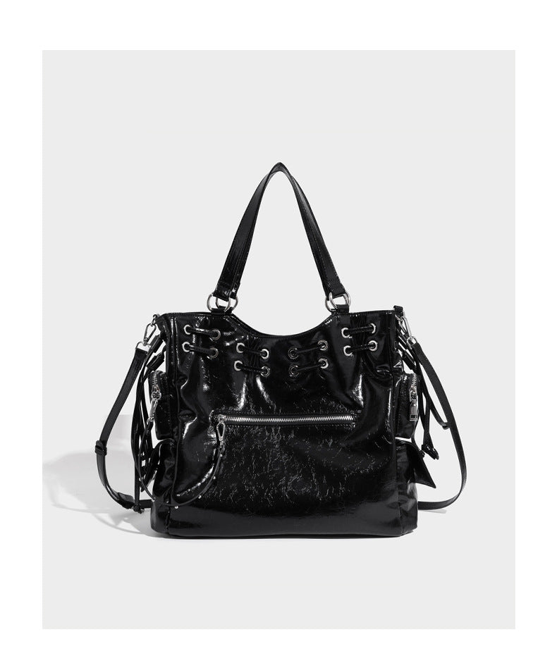 Glossy crinkled leather-look tote bag with silver grommet lace-up front detail, dual top handles, and detachable shoulder