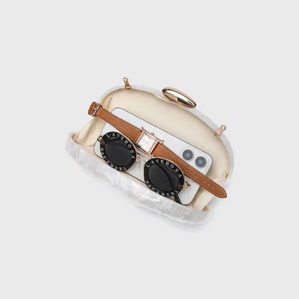 Oval pearl-finish shell clutch bag with gold-tone clasp and removable gold link chain strap, detail view 4