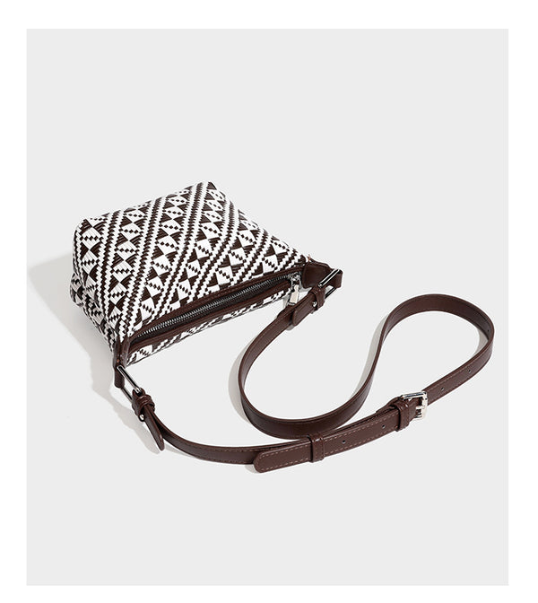 Kleine schwarz-weiße Schultertasche mit gewebtem geometrischem Muster, glatter dunkelbrauner Besatz aus Lederoptik, geknotetem verstellbarem Riemen und seitlichem